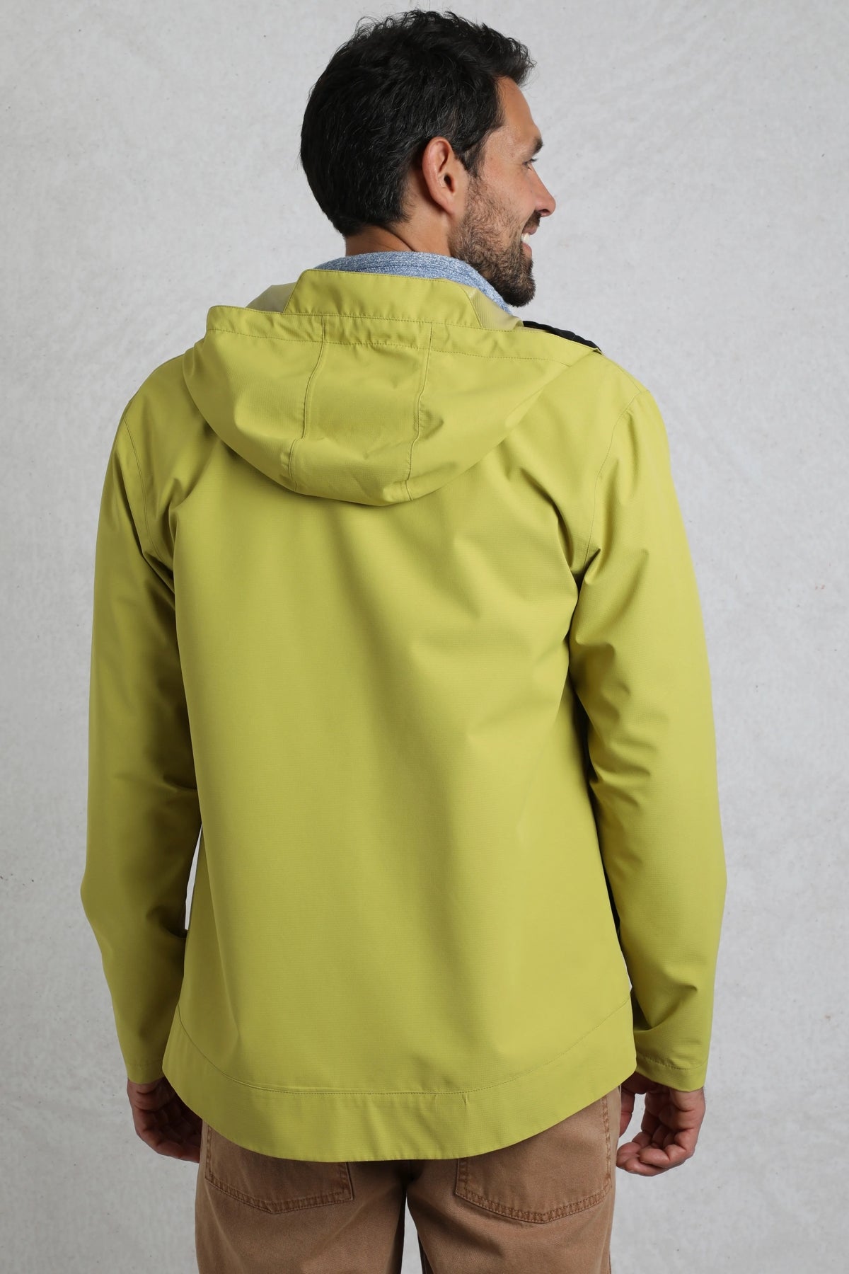 Back view of man wearing Weird Fish mens waterproof jacket tarragon in green with hood