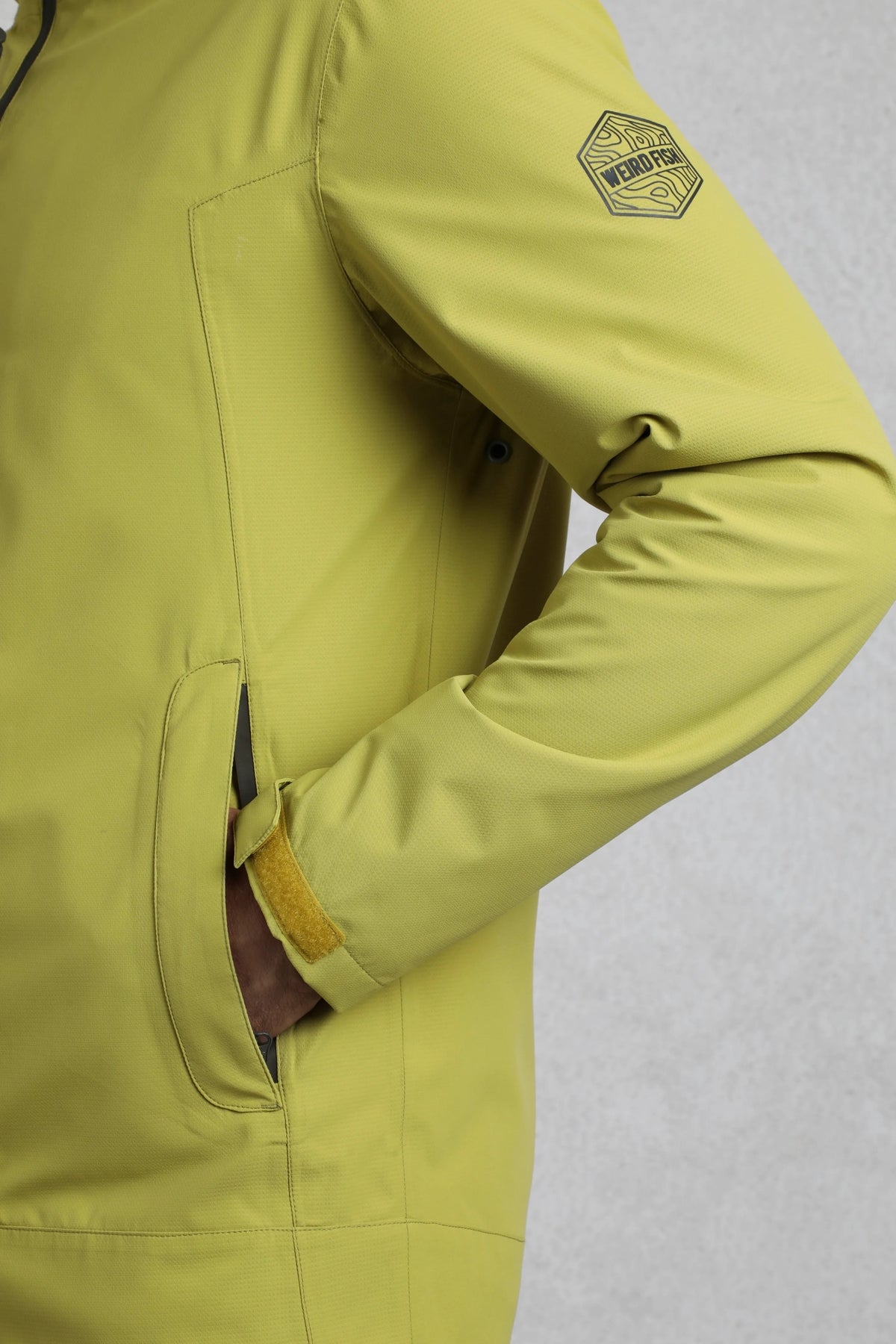 Weird Fish mens waterproof jacket tarragon with zippered pocket and adjustable cuff in yellow green
