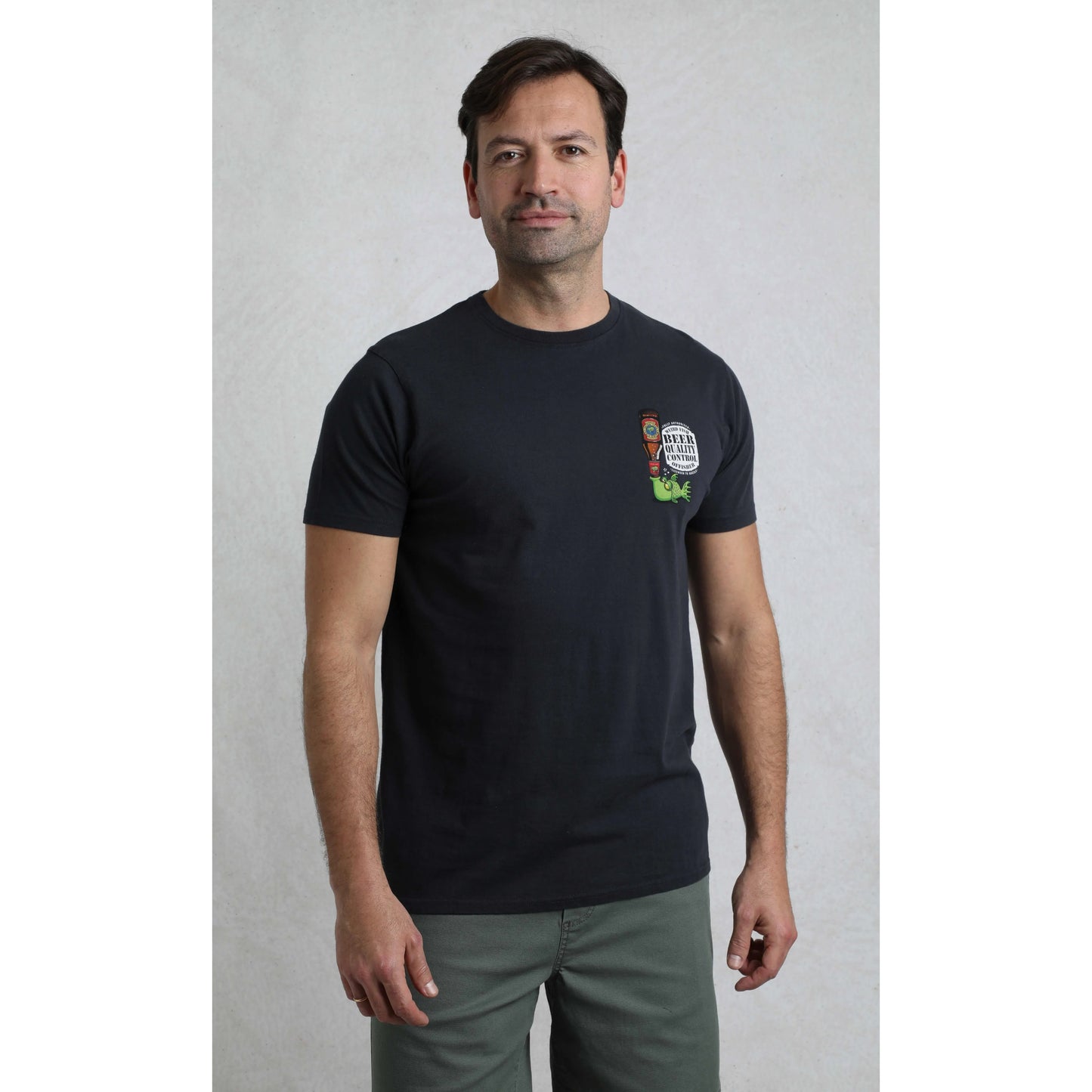 Man wearing a black t-shirt with a logo on a plain background