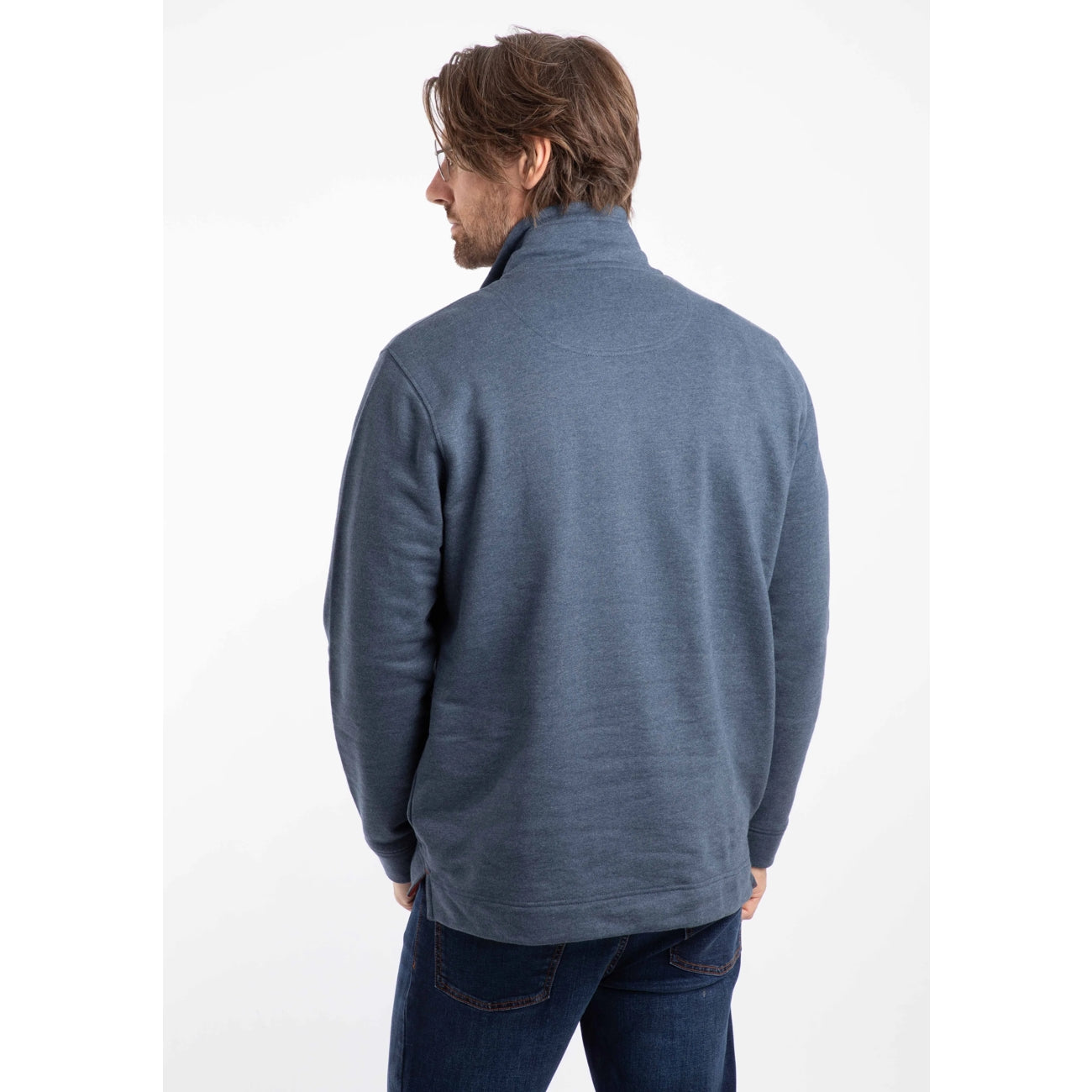 Man wearing a Weird Fish navy blue Brampton sweatshirt and jeans on a white background