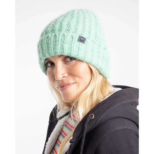 Woman wearing a Weird Fish knitted Clare beanie in Sea Mist turquoise-green and dark jacket with a striped shirt on a white background