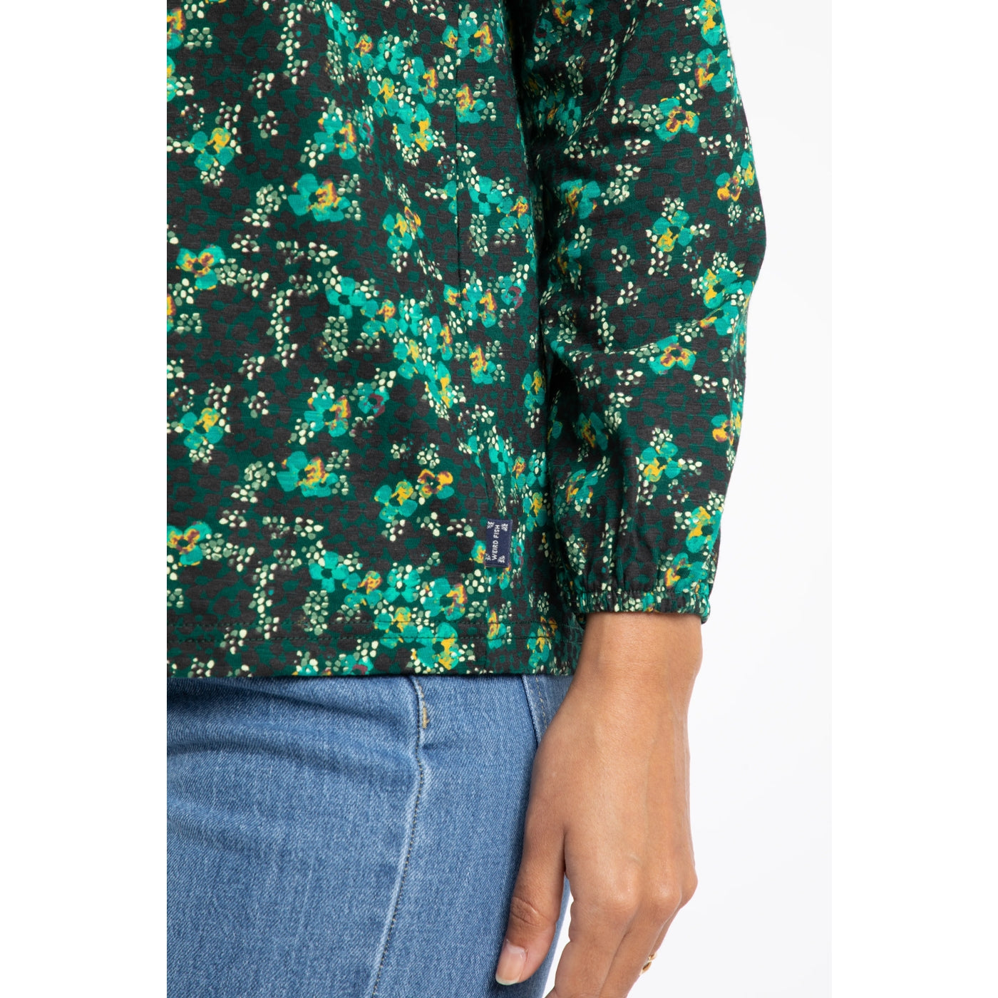 Close up of a womens Weird Fish long sleeve Brooke top in a green floral pattern on a white background