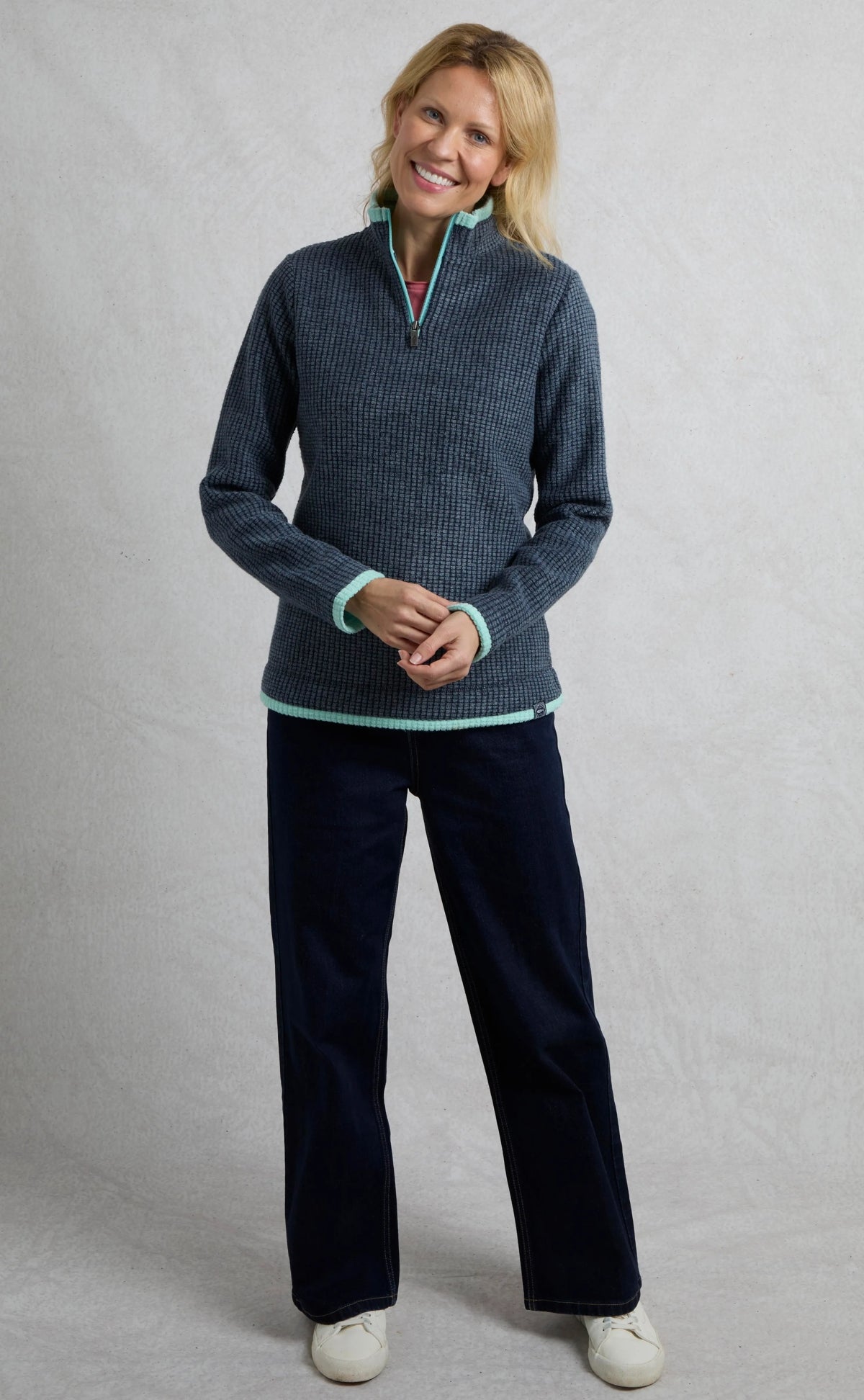 Weird Fish womens fleece navy blue half-zip pullover worn by smiling woman with light trim details
