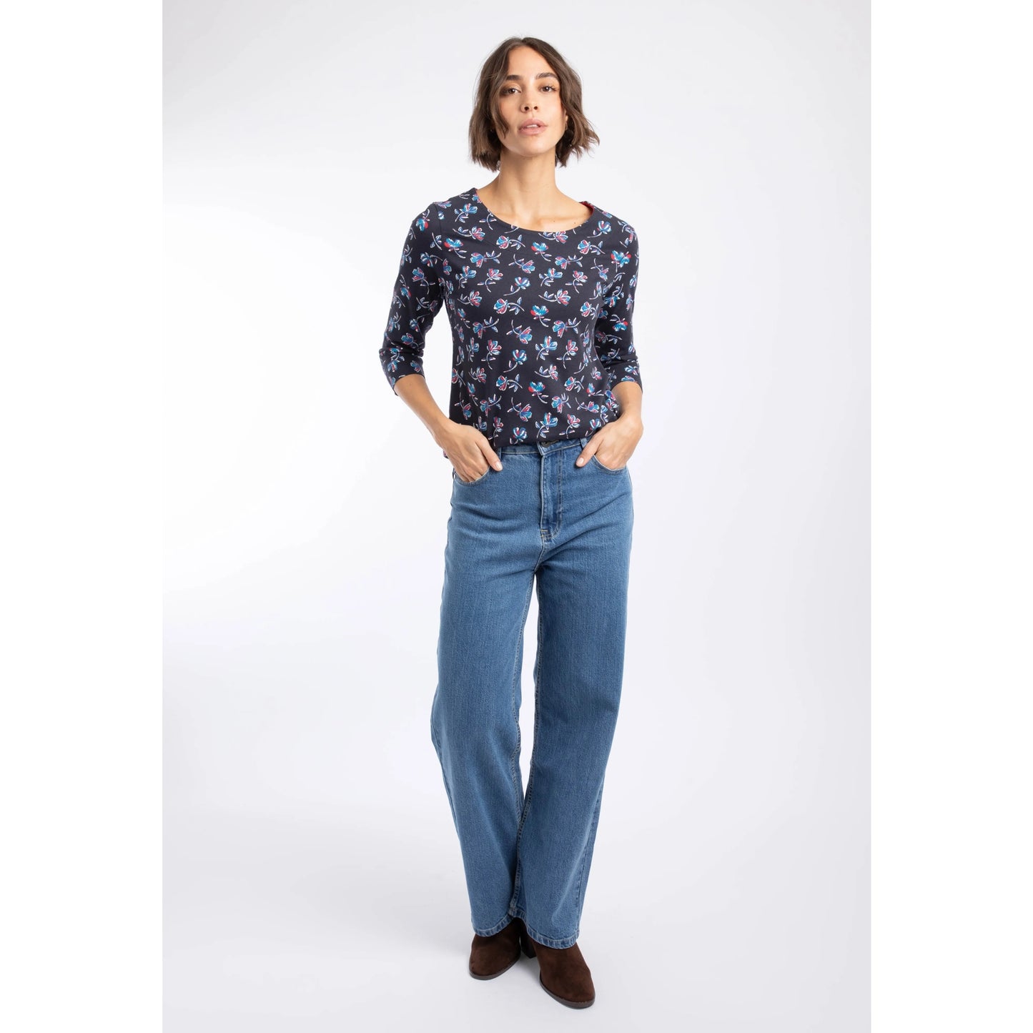 A woman wearing a Weird Fish three-quarter sleeve Pinto t-shirt in Midnight Navy with a blue and red floral pattern with blue jeans.