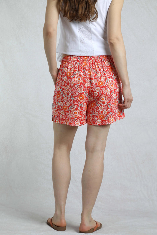 Back view of Weird Fish womens red floral shorts worn with a white sleeveless top and sandals