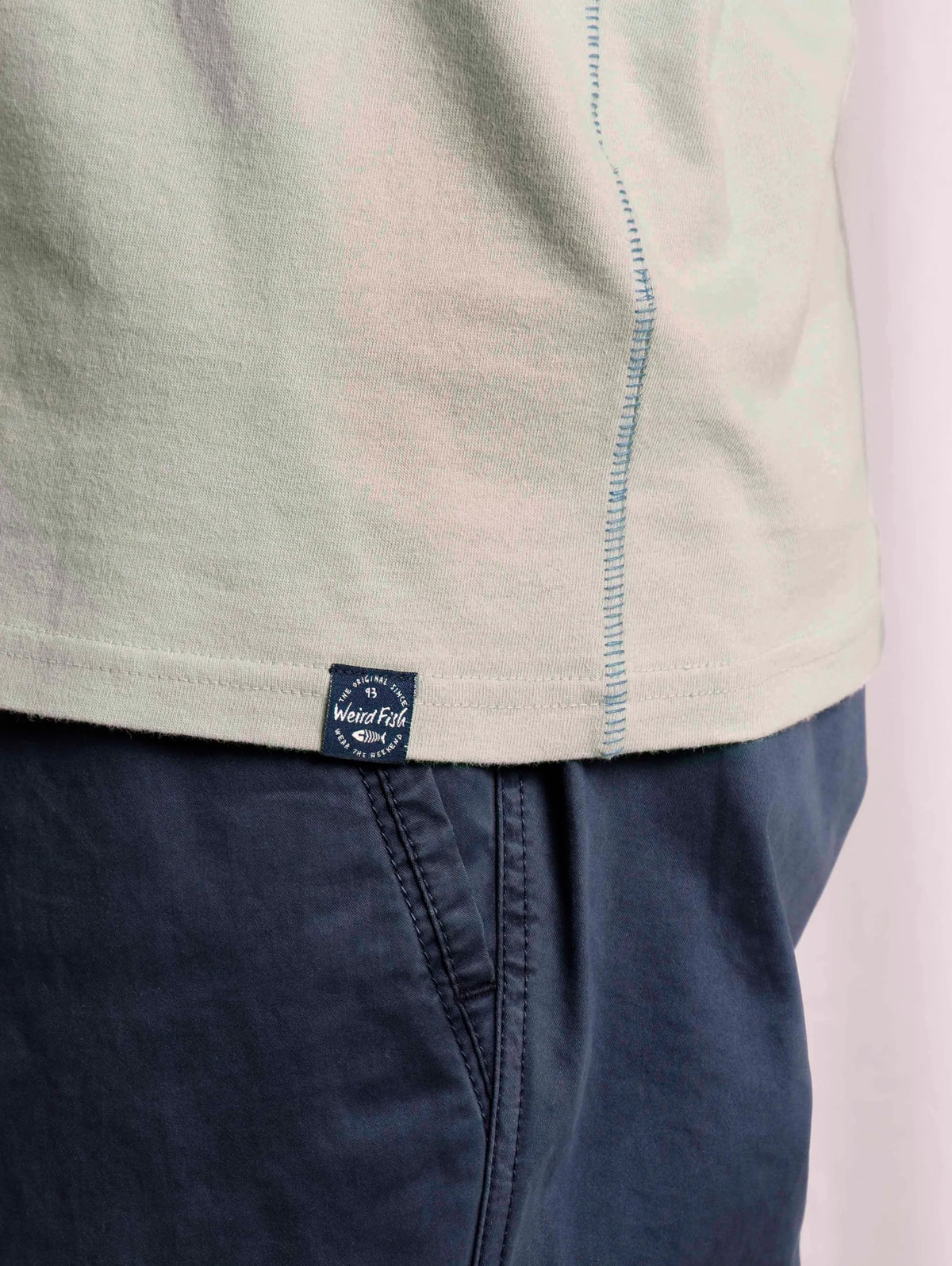 Men's Pistachio Green coloured tee from Weird Fish with Original Surf logo print design and small logo label on the bottom hem.
