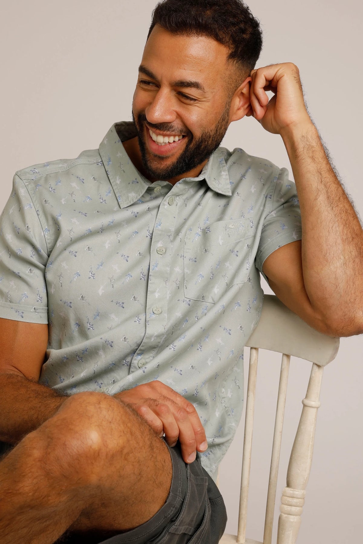 Men's Keilor shirt from Weird Fish in pistachio green with short sleeves, button through front and a fish print pattern.