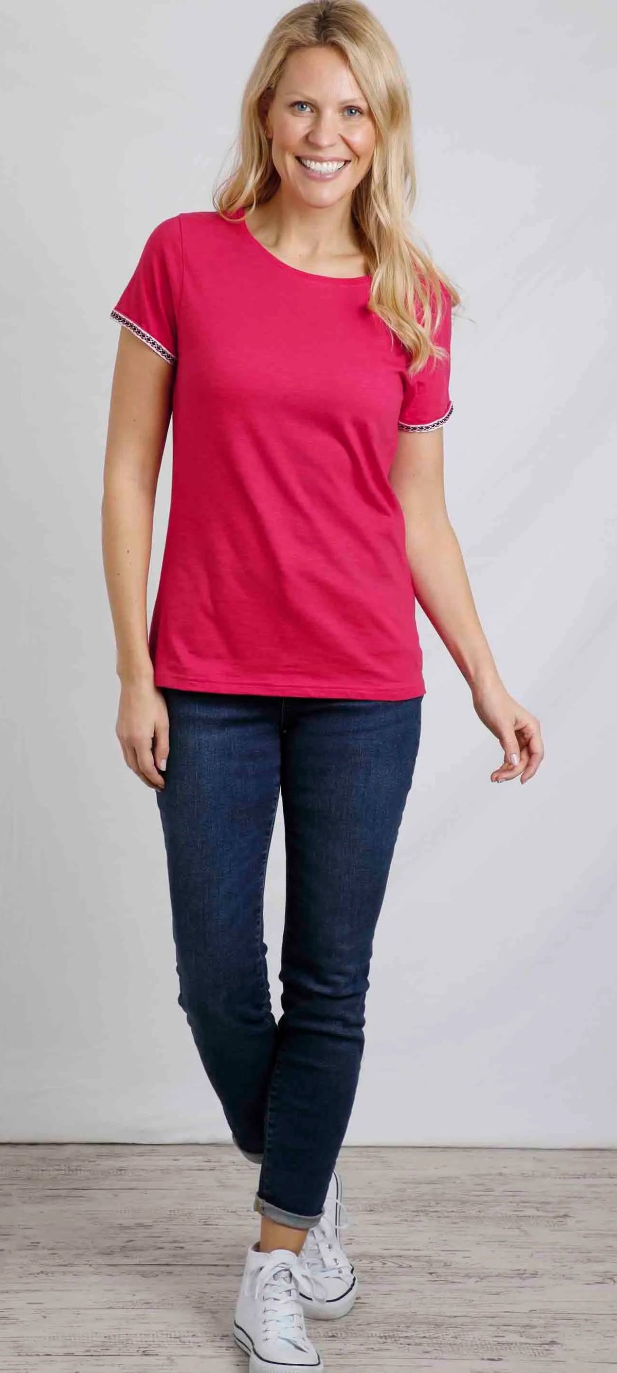 Weird Fish womens Teya t-shirt in Hot Pink modeled by a smiling woman wearing jeans and white trainers