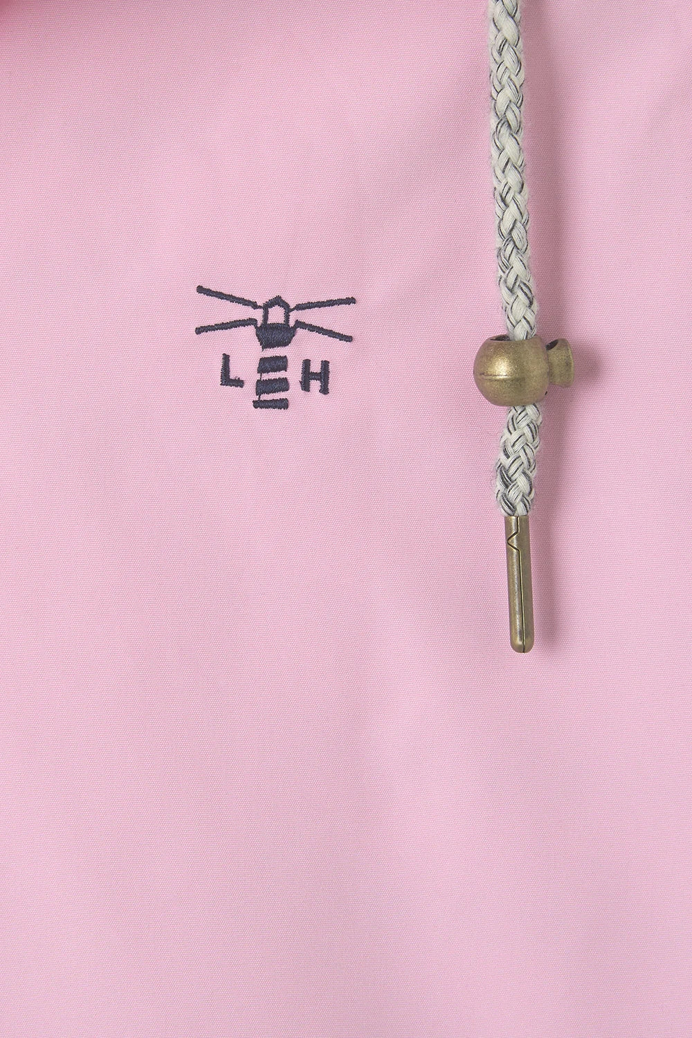 Close-up of Lighthouse womens waterproof jacket pink showing logo and drawstring details