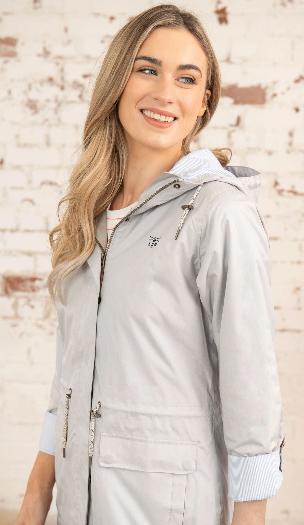 Lighthouse women's Alice waterproof rain coat in Sand with drawstring waist and roll back sleeves.