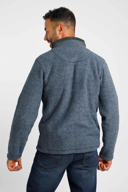 Man wearing Weird Fish Newark fleece jacket in blue, featuring a high collar and textured design