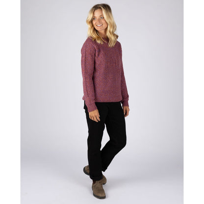 A woman wearing a Saltrock Lucy crew neck longline knitted jumper in purple with black trousers and boots.