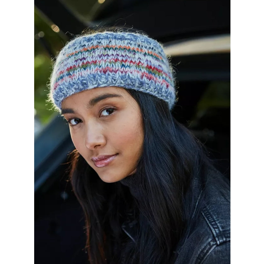 Woman wearing a multicolour knitted Pachamama Coroico headband with blurred background