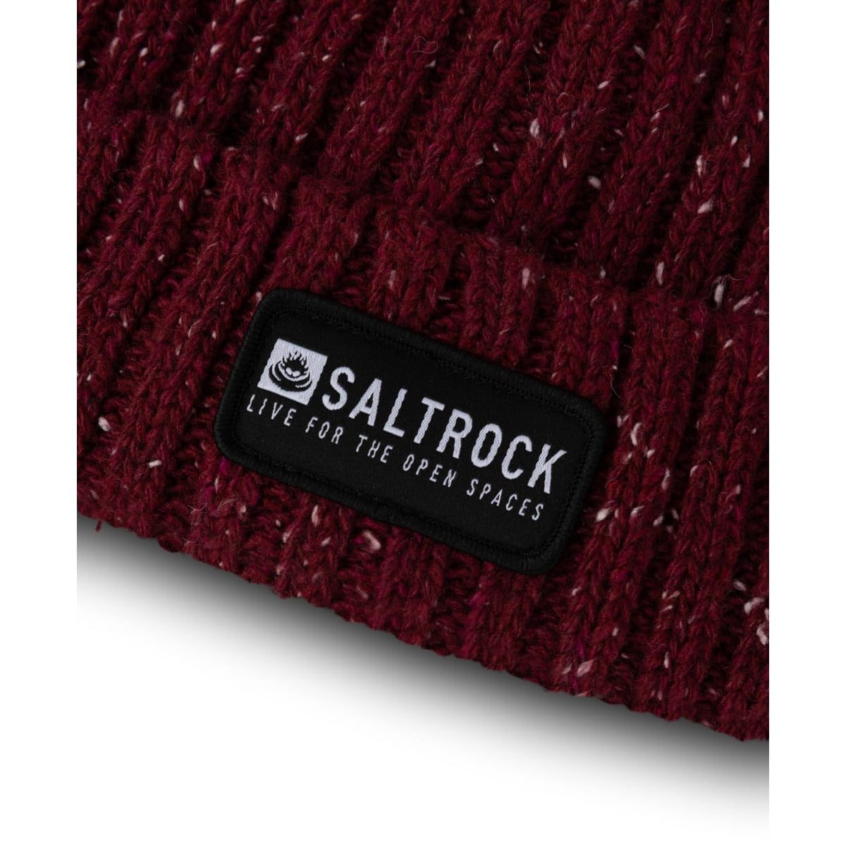 Close-up view of the hem and logo patch of an adults Saltrock Heritage ribbed knit beanie in Burgundy red with a white fleck.