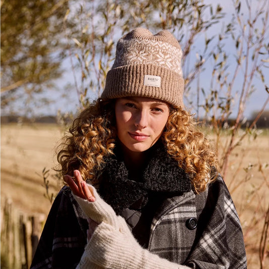 Woman wearing a Barts Negomba Fair Isle patterned knitted hat in Light Brown and plaid coat outdoors