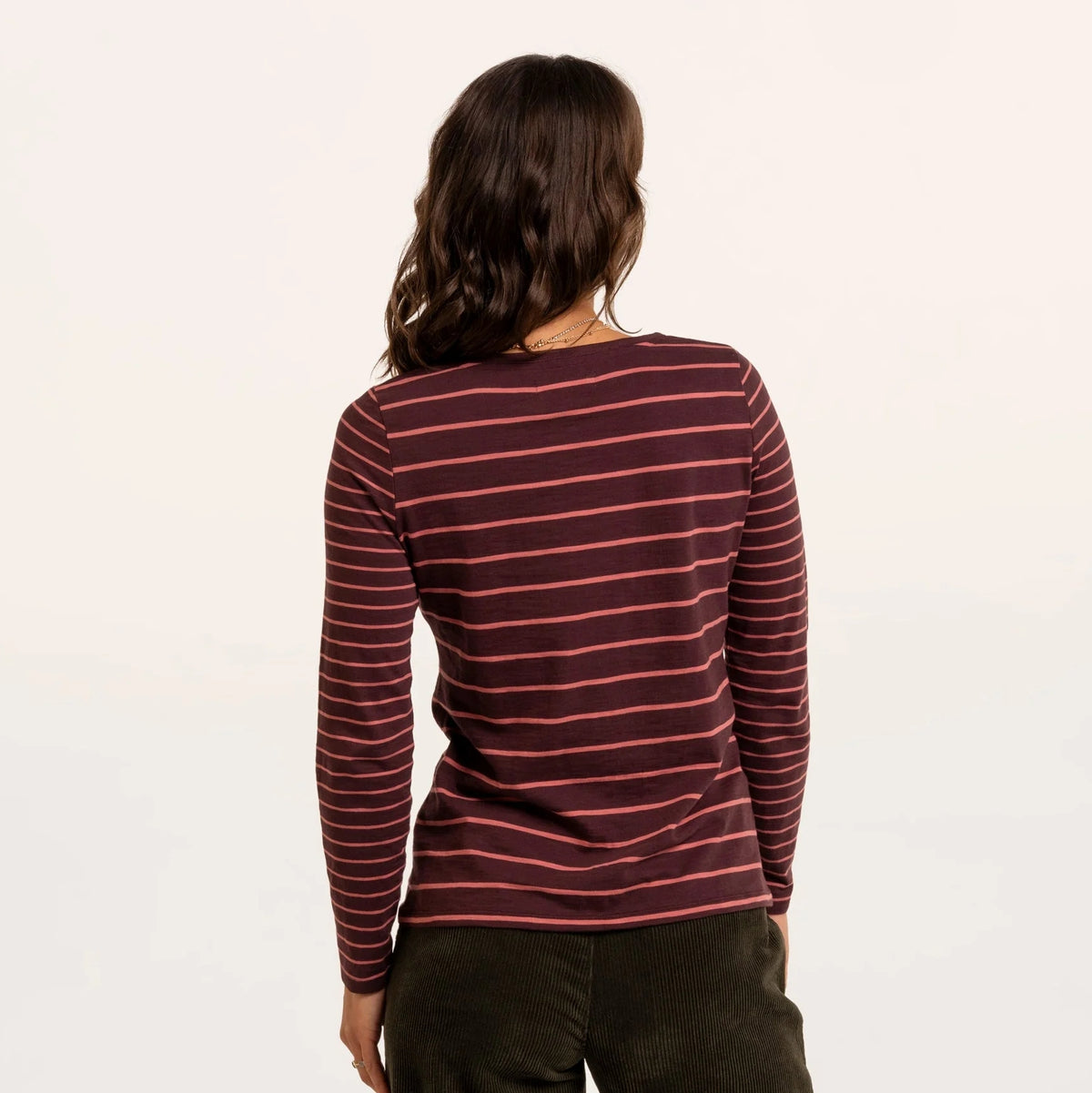 Back view of a woman wearing a Brakeburn long sleeve thick and thin stripe Branksome t-shirt in burgundy with coral stripes.