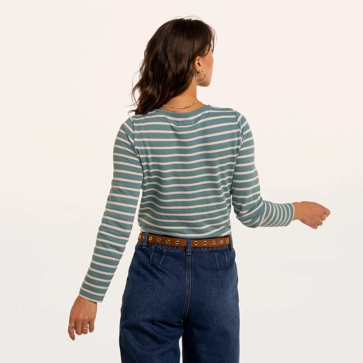 Backk view of a woman wearing a Brakeburn long sleeve textured Studland t-shirt in turquoise with a white stripe pattern.