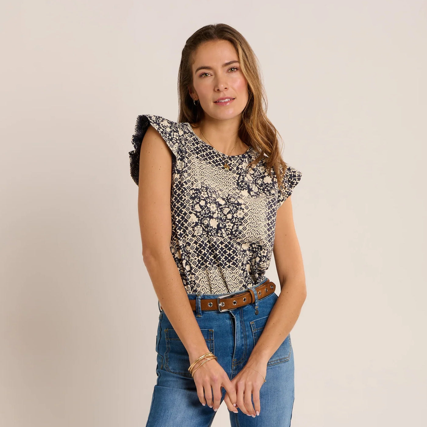 Front view of a woman wearing a Brakeburn short sleeve Salinas blouse in a cream and navy patchwork floral print