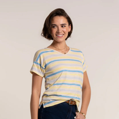 Woman wearing a Brakeburn short sleeve Seas t-shirt in a blue and yellow stripe pattern, with v-shape neckline.