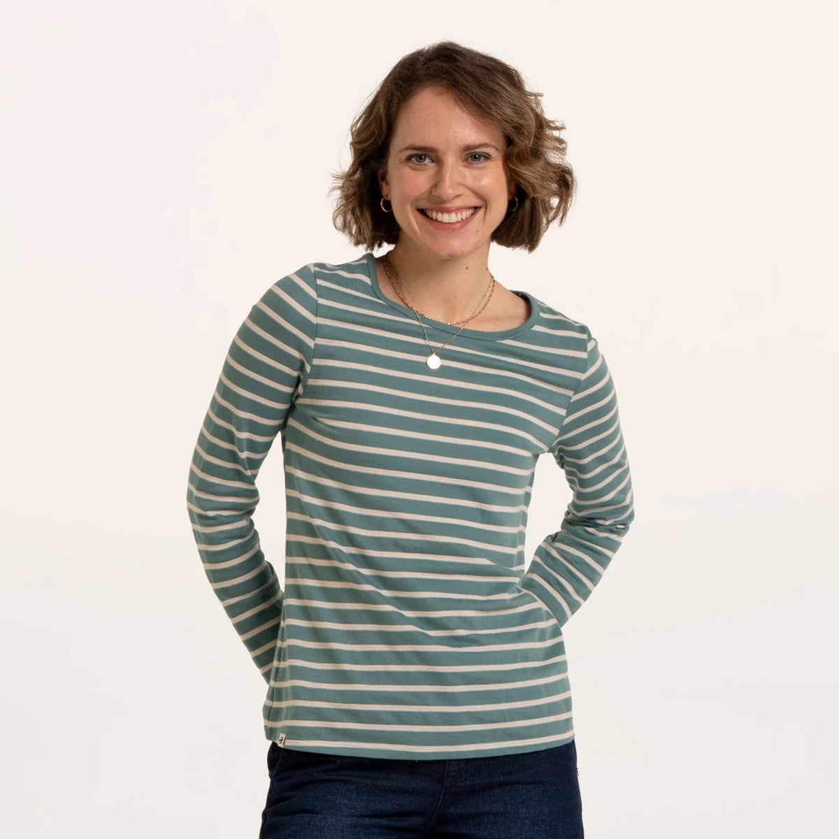 Front view of a woman wearing a Brakeburn long sleeve textured Studland t-shirt in turquoise with a white stripe pattern.