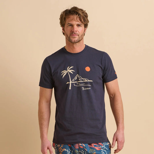 Front view of a man wearing a navy blue Brakeburn t-shirt with a palm tree and island mountain design on a beige background