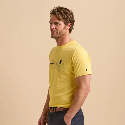 Side view of a man wearing a Brakeburn South Coast Surf print t-shirt on a beige background