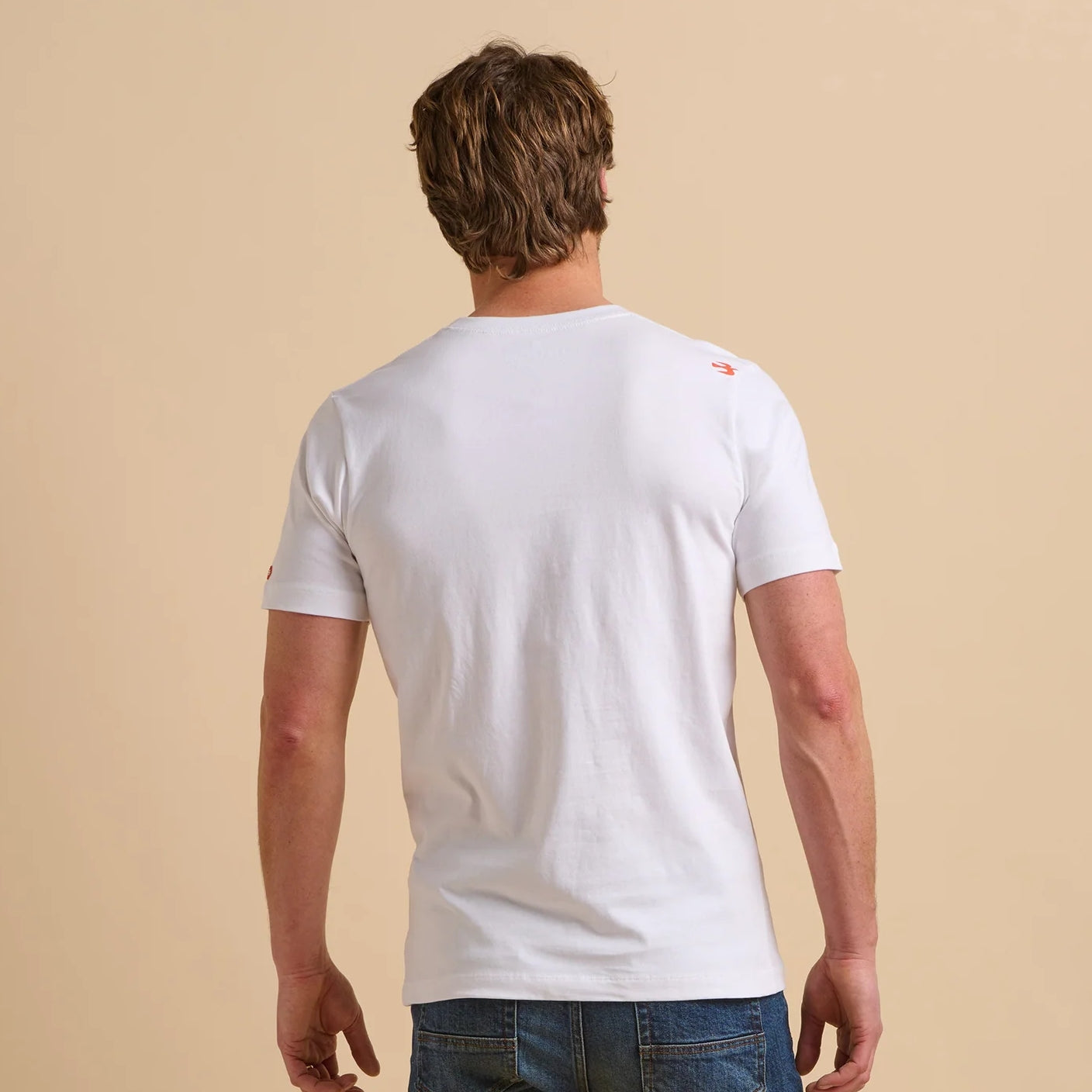 Back view of a man wearing a Brakeburn short sleeve white t-shirt on a beige background