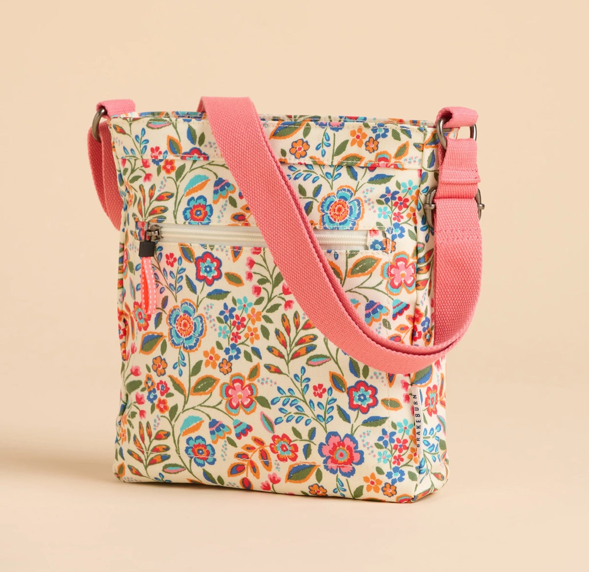 Brakeburn Secret Garden floral cross body bag with pink adjustable strap and colorful flower pattern