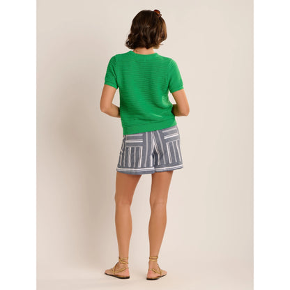 Back view of a woman wearing a pair of Brakeburn loose fit Lettie beach shorts in Navy with a white vertical stripe pattern with an elastic waist.