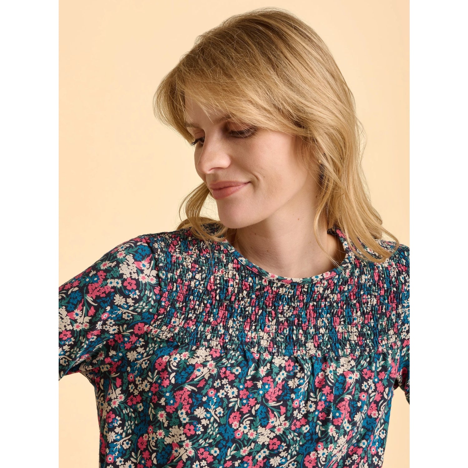 Woman wearing a multicolour floral Brakeburn long sleeve Brenda t-shirt against a beige background