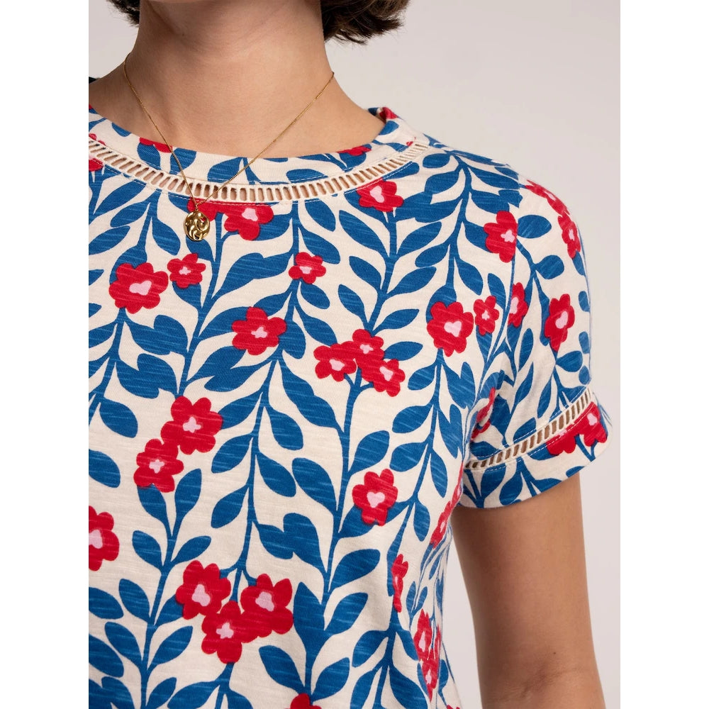 Close-up front view of a woman wearing a Brakeburn short sleeve Clara t-shirt with a blue and red floral pattern and lace trim around the neckline and sleeves.