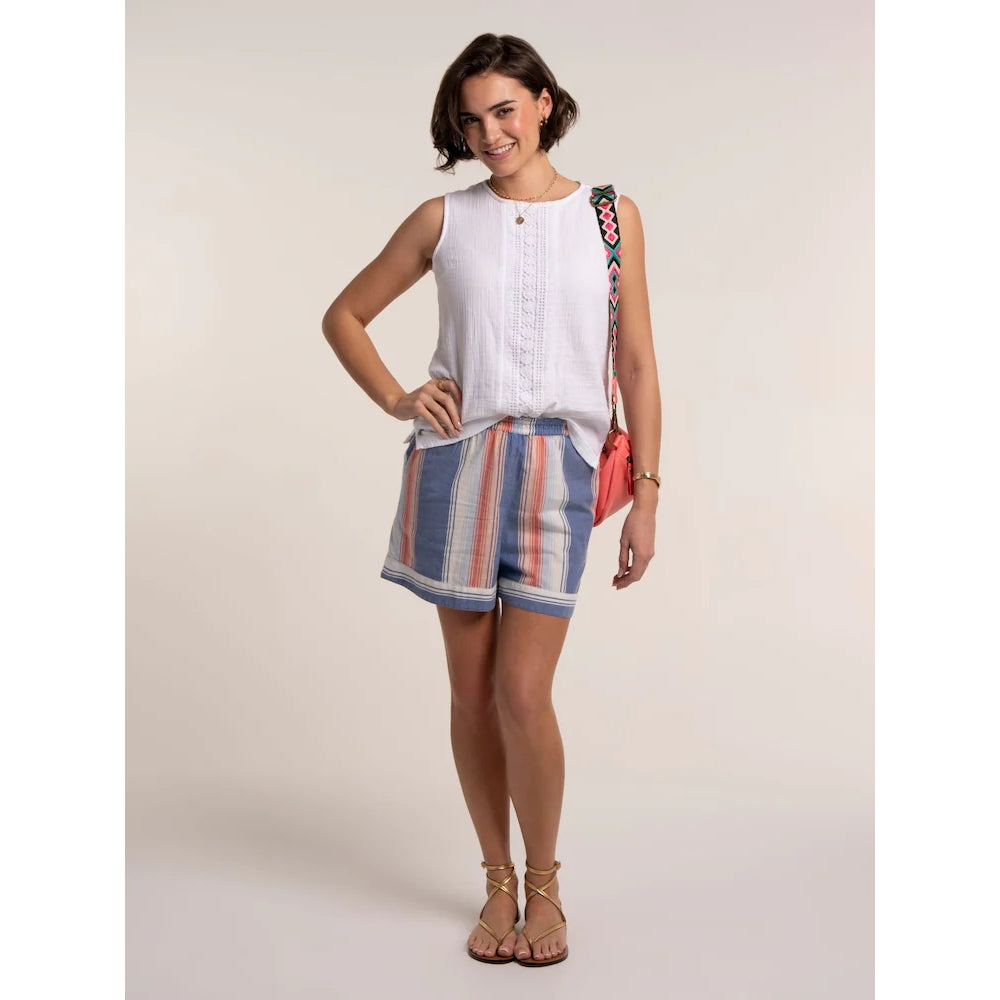 Front view of a woman wearing a pair of Brakeburn Constanza beach shorts in a blue and coral vertical stripe pattern with an elastic waist.