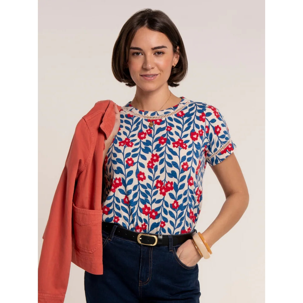 Front view of a woman wearing a Brakeburn short sleeve Clara t-shirt with a blue and red floral pattern and lace trim around the neckline and sleeves.