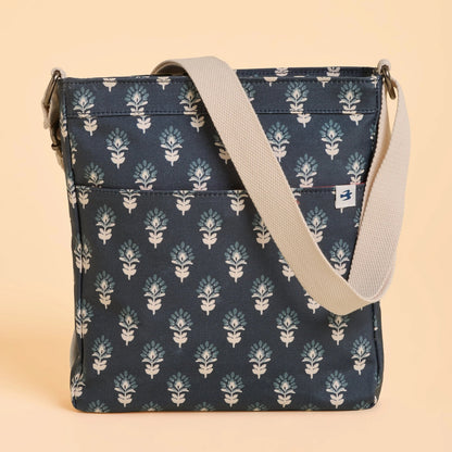 Back view of a Brakeburn Henna floral patterned bag with beige strap on a beige background