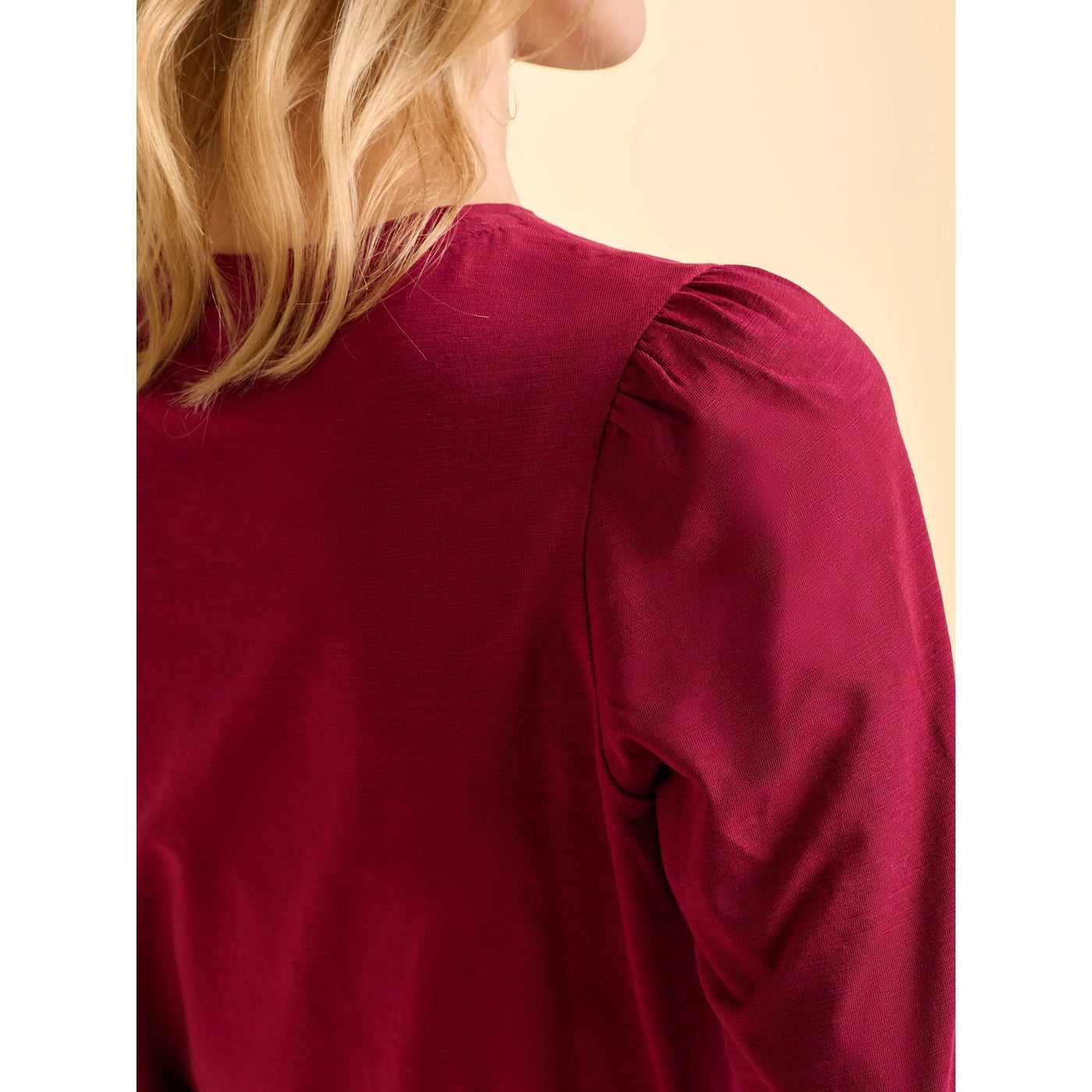 Close-up of a womens Brakeburn Janis burgundy t-shirt with long sleeves and gathered shoulders on a plain background