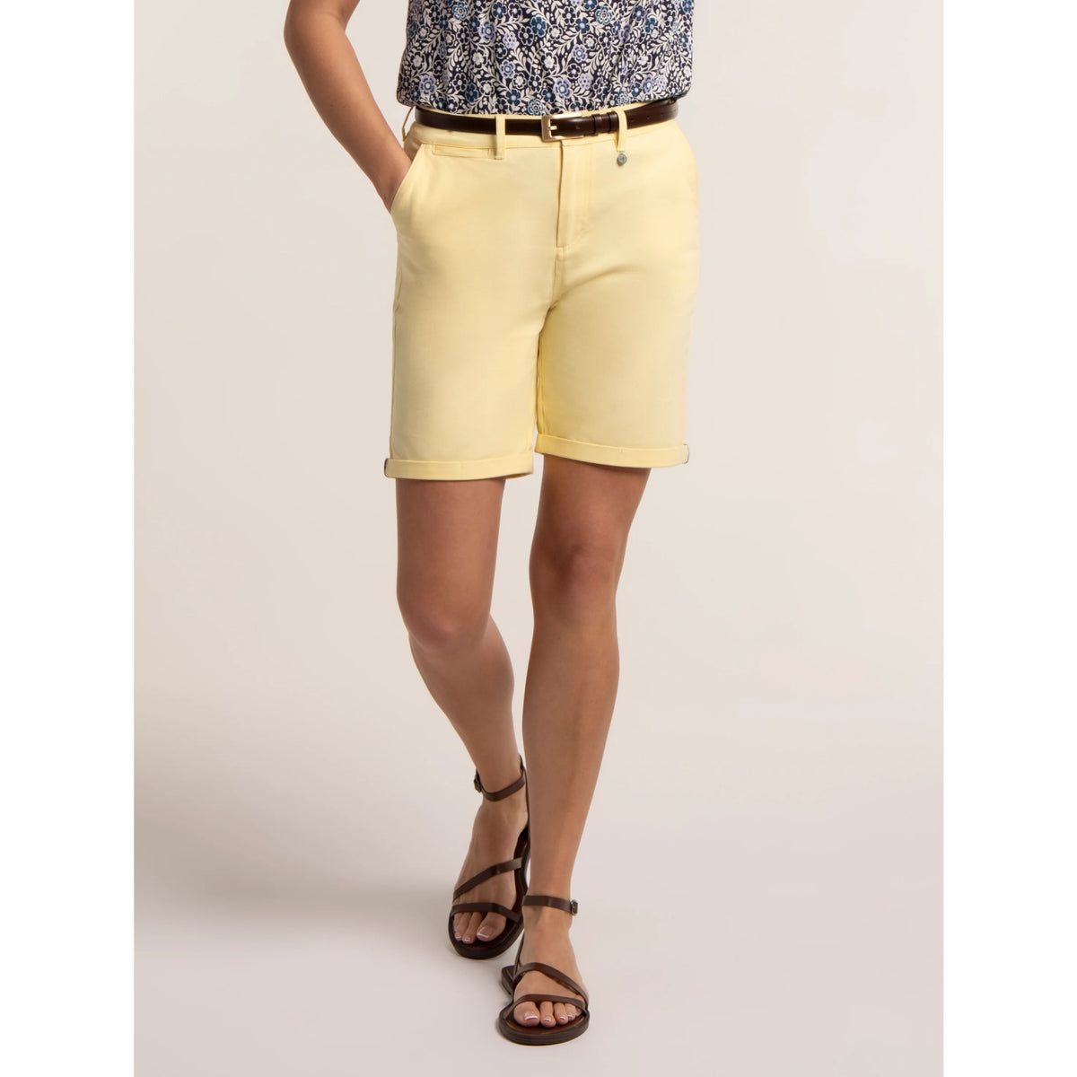 Front view of a woman wearing a pair of Brakeburn chino shorts in a soft yellow shade.