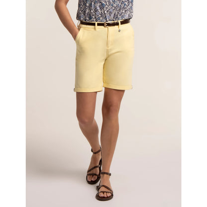 Front view of a woman wearing a pair of Brakeburn chino shorts in a soft yellow shade.