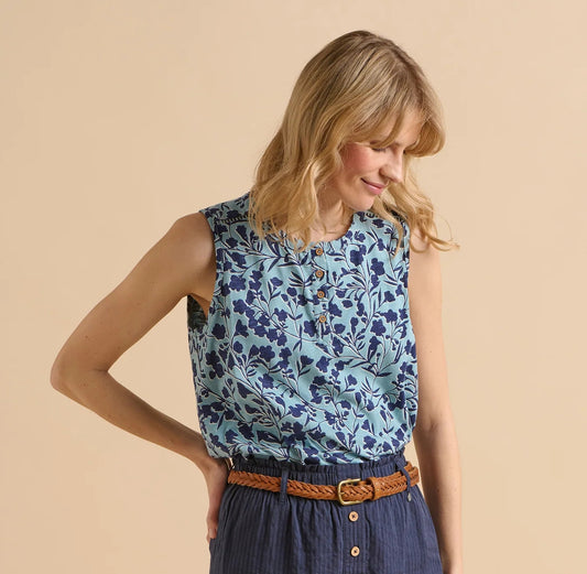 Front view of a woman wearing a sleeveless Brakeburn Shadow Floral Vest top in a two tone blue pattern, on a beige background