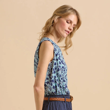 Side view of a woman wearing a Brakeburn two tone blue floral vest against a beige background