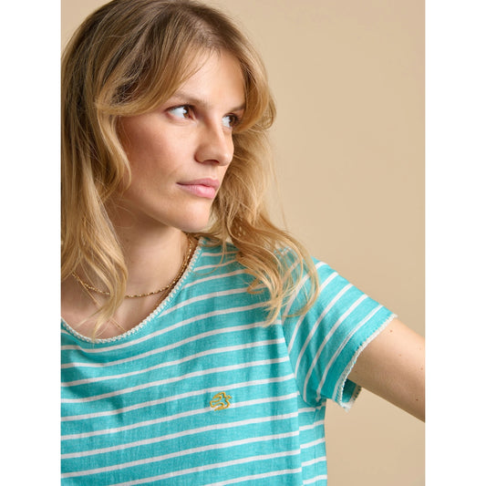 Close up of a woman wearing a Brakeburn aqua and white stripe short sleeve t-shirt with a yellow embroidered bird logo, on a beige background