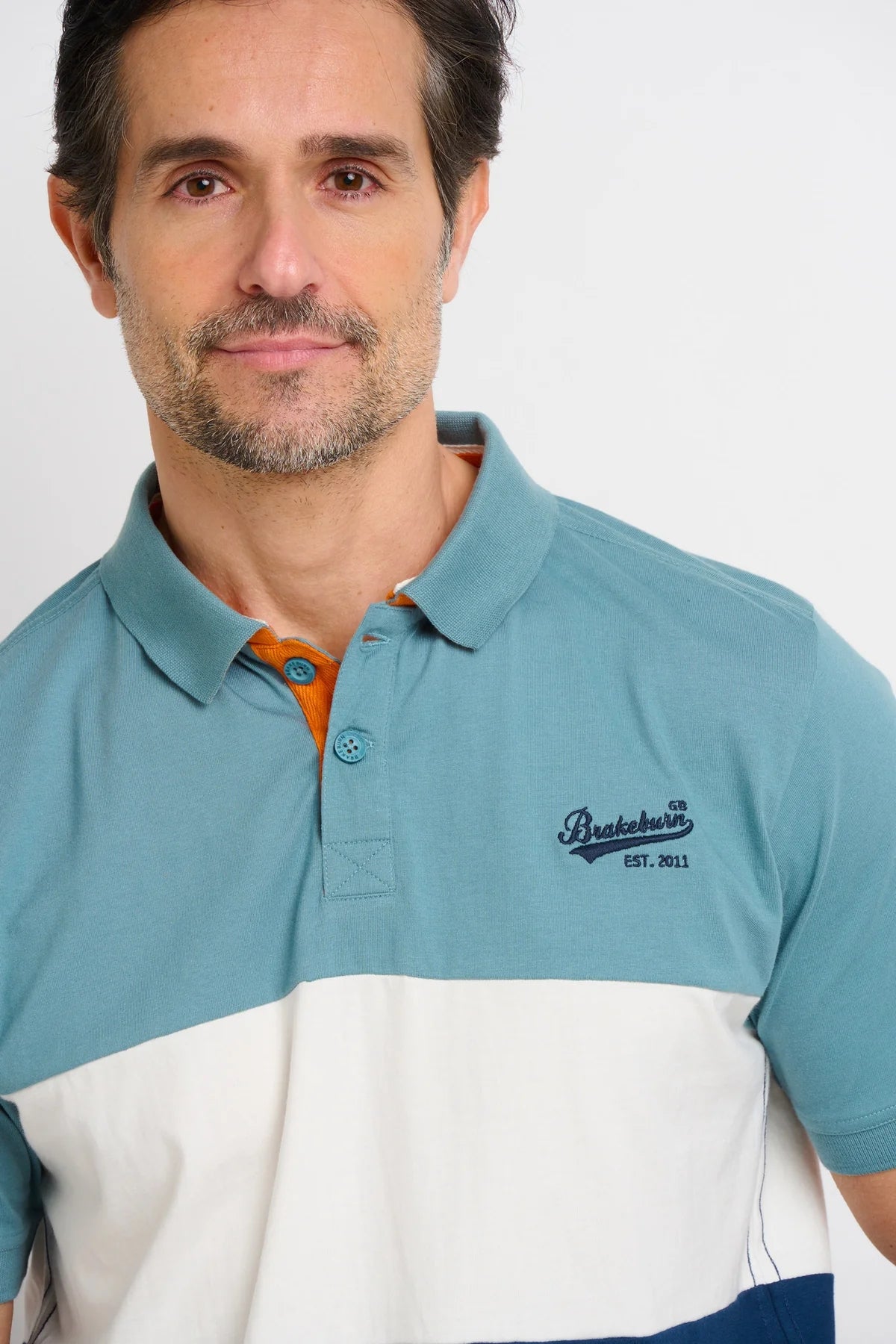 Men's short sleeve polo shirt from Brakeburn in a blue, white and navy colour block style pattern.