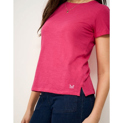 Woman wearing a Crew Clothing Perfect short sleeve plain t-shirt in raspberry pink with small embroidered logo by the hem and side seam slits
