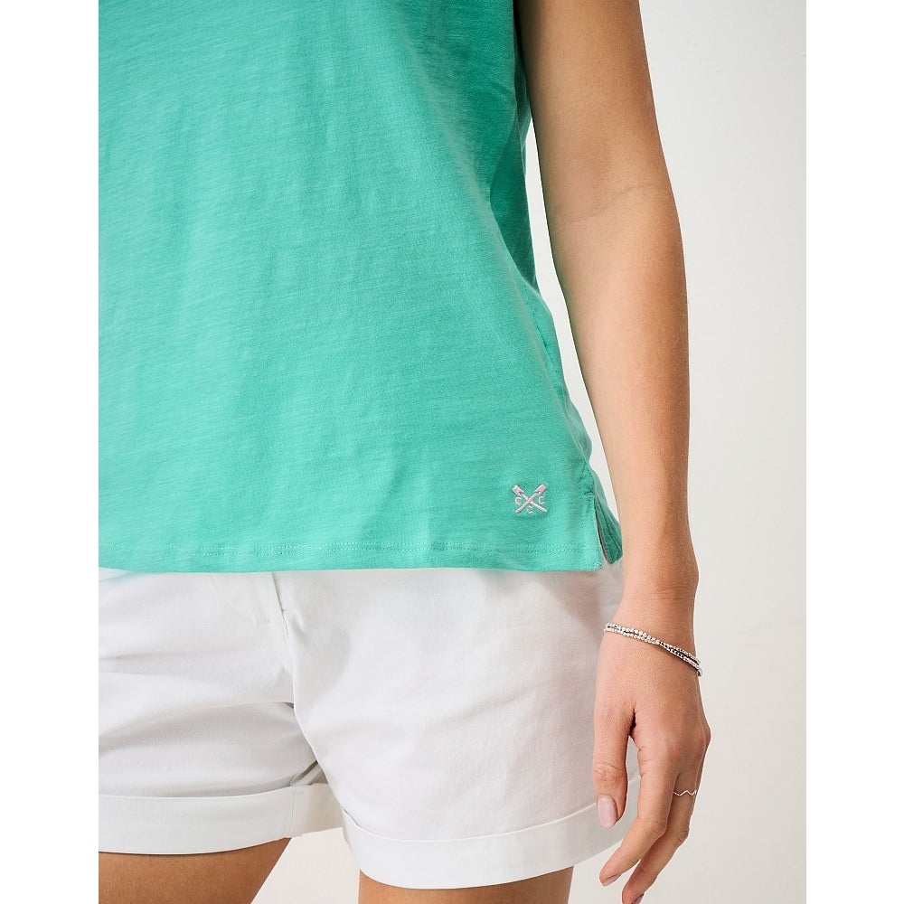 Woman wearing a Crew Clothing Perfect short sleeve plain t-shirt in Pool Blue turquoise with a small embroidered logo by the hem and side seam slits