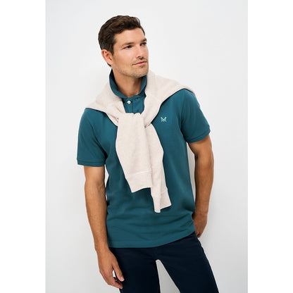 Front view of a man wearing a Crew Clothing short sleeve classic pique polo shirt in Teal with small crossed oars logo on the chest