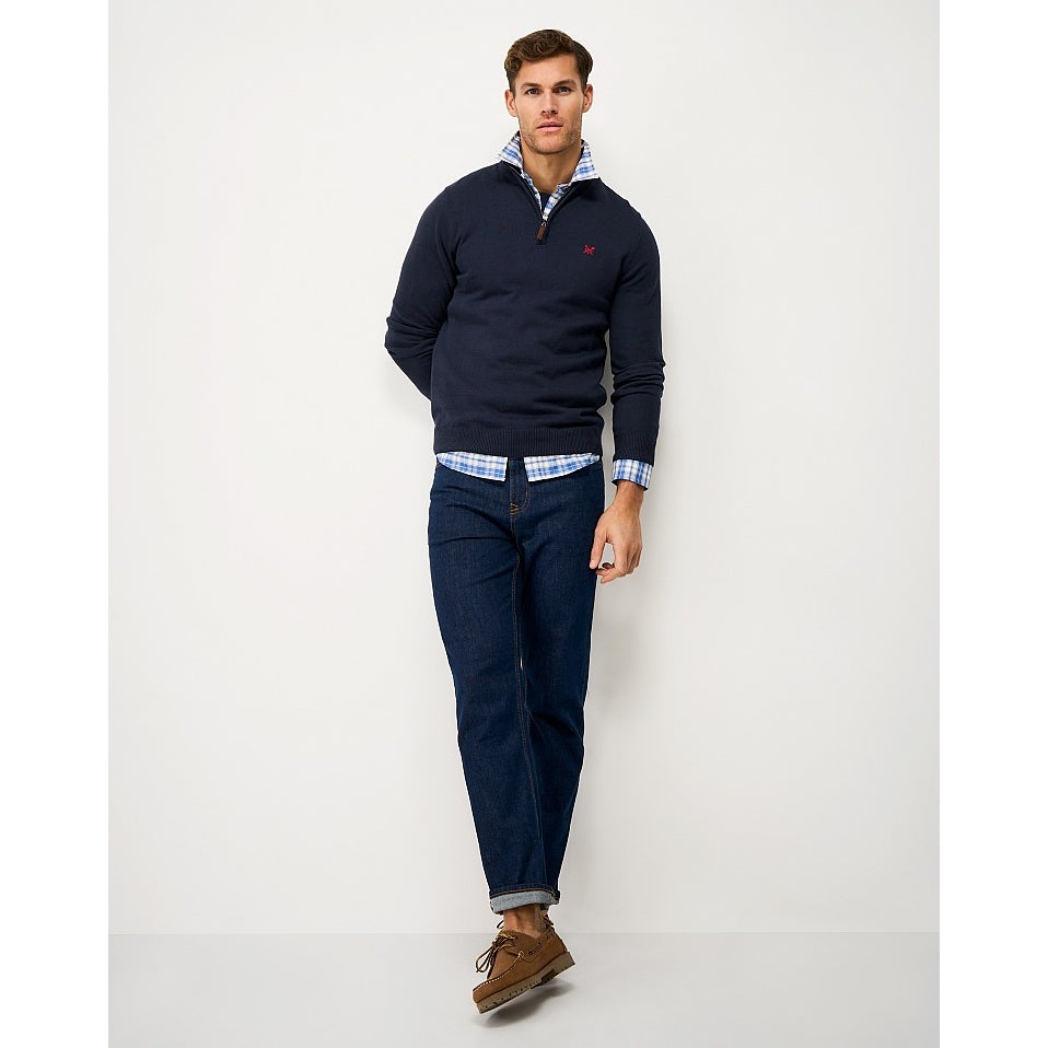 Front view of a man wearing a Crew Clothing 1/4 zip classic knitted jumper in Heritage Navy, jeans and brown shoes.