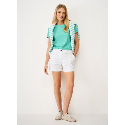 Woman wearing a Crew Clothing Perfect short sleeve plain t-shirt in Pool Blue turquoise with white shorts and trainers