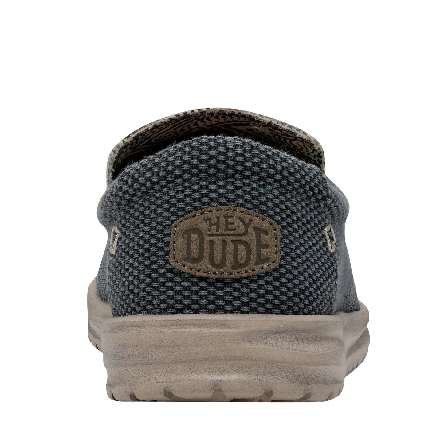 Back heel view of a men's Dude Mikka Braided lightweight slip on canvas shoe in Deep Blue with Hey Dude logo label.