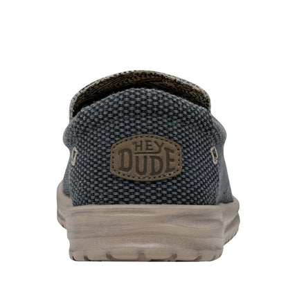 Back heel view of a men's Dude Mikka Braided lightweight slip on canvas shoe in Deep Blue with Hey Dude logo label.