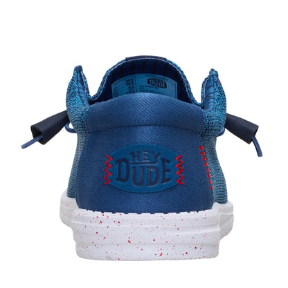 Back heel view of a men's Dude Wally Stretch Sox lightweight mesh shoe in Ensign Blue / Multi, with elastic laces, a white speckled sole and plain blue back panel with Hey Dude logo.