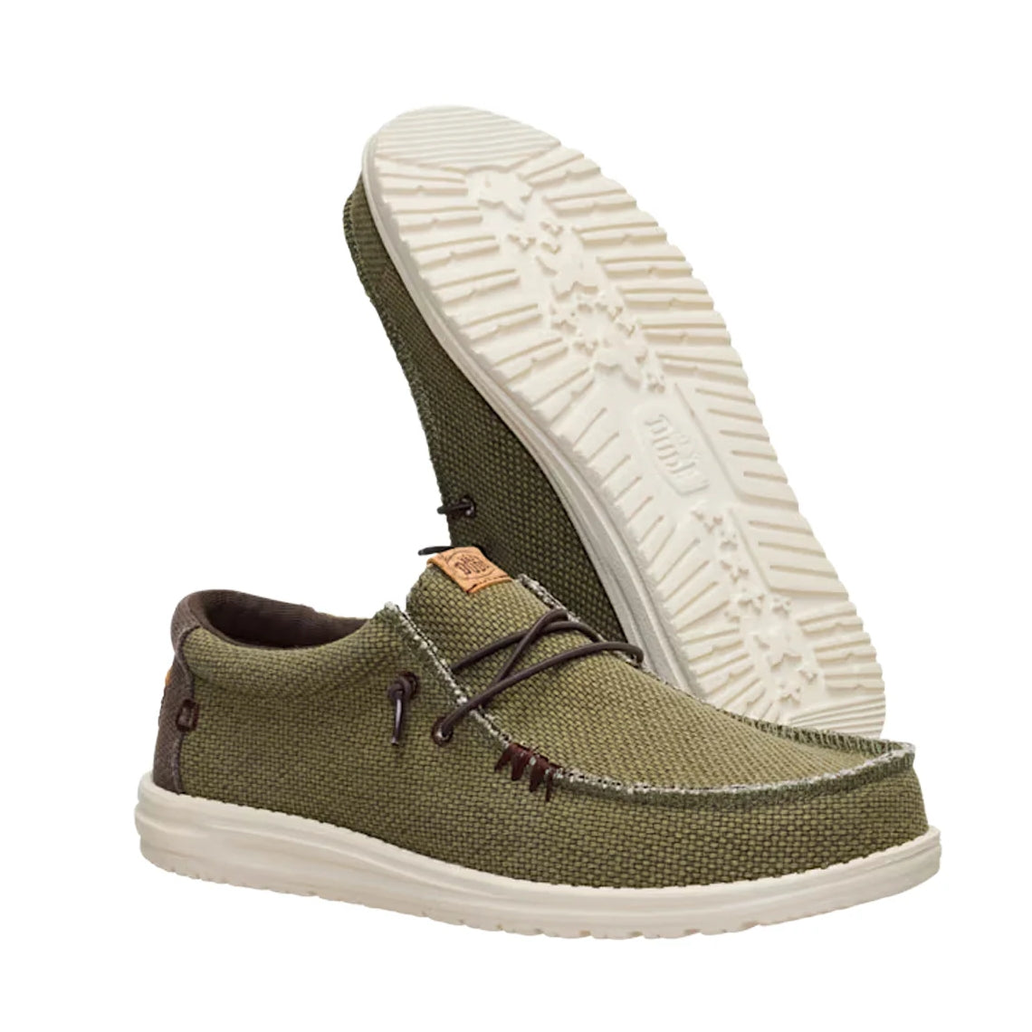 A pair of men's Dude Wally Braided lightweight canvas shoe in Burnt Olive / Delicioso Brown in a slip on style with laces, with one shoe upside down showing the outsole.